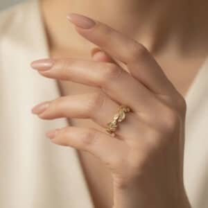 Matte 14K white gold wedding band with hand-carved vine and leaf pattern surrounding the entire ring.