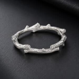 Organic gold wedding band with tree branch texture and scattered burnish-set diamonds.