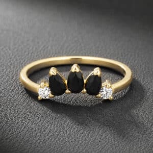 Black diamond V curved guard band in 14K yellow gold featuring eleven micropavé black diamonds in a minimalist chevron contour wedding band design.