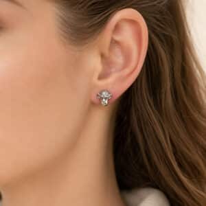 White gold chimpanzee stud earrings displayed on dark metallic satin fabric.