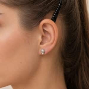 Woman wearing small chimpanzee head stud earrings in white gold by OroSpot.