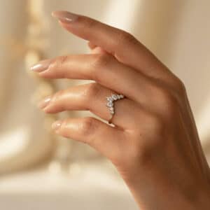 14K yellow gold curved nesting diamond band worn on a finger, featuring lab-grown diamonds and a satin finish.