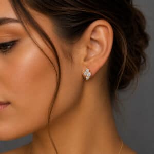 Woman wearing small diamond cluster stud earrings in 14K yellow gold by OroSpot.