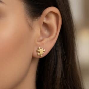 Unique puzzle shaped gold stud earrings in polished 14K yellow gold with modern symbolic design