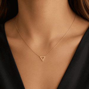 Woman wearing a minimalist 14K yellow gold triangle diamond necklace by OroSpot.