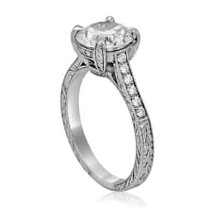 Vintage diamond engagement ring with hand engraving and milgrain detailing in white gold or platinum setting.