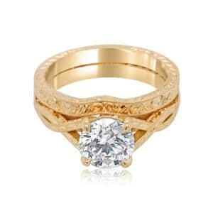 Antique-style diamond engagement ring set with hand-engraved detailing, milgrain edges, and a matching wedding band in vintage-inspired design.