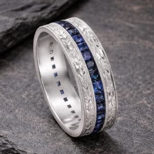 mens wedding band with full eternity blue sapphire channel, hand engraved sides, milgrain edges and comfort fit in white gold or platinum by orospot
