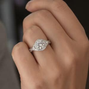 Braided engagement ring with a halo-set 1.5ct lab-grown diamond, bezel accents, hand engraving, and pavé diamonds.