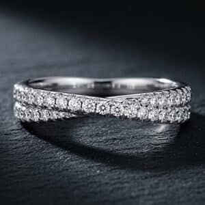 Braided diamond wedding band featuring an overlapping design and French cut-down diamonds in solid precious metal.