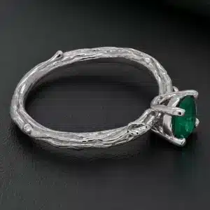 Organic emerald leaf engagement ring with tree branch band and natural woodland-inspired design.