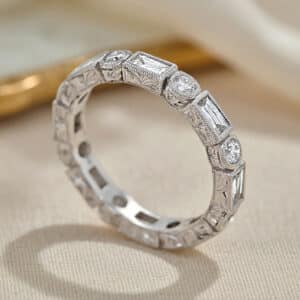 Luxury 14K white gold hand-engraved vintage eternity wedding band with baguette and round cut diamonds.