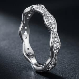 White gold eternity wedding band with a wave profile and continuous pavé-set diamonds encircling the ring.