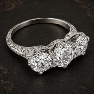 edwardian 3 stone engagement ring with 7.5 mm center diamond and two 6.5 mm side stones, hand engraved band, milgrain detail, vintage inspired orospot