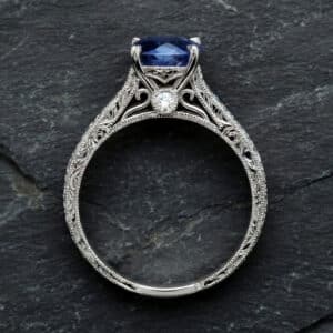 antique sapphire engagement ring with hand engraving, vintage style band, blue sapphire center in white gold
