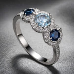 Aquamarine sapphire engagement ring with round blue gemstones, diamond halos, and white gold three-stone vintage-inspired design by OroSpot.