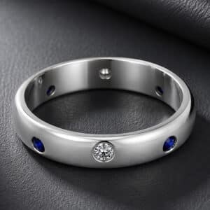 14K white gold domed wedding band featuring burnish-set blue sapphires and diamonds with a smooth high-polish finish.