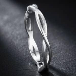 Slim braided wedding band with a modern love knot design and polished finish in precious metal.