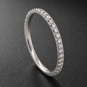 Slim 1.6mm diamond wedding band featuring natural G-VS diamonds in a French cut-down setting and a minimalist profile.