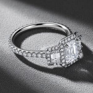 Contemporary engagement ring with emerald-cut lab diamond, trapezoid side stones, and diamond halo by OroSpot.