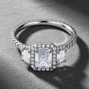Emerald-cut halo engagement ring with trapezoid lab diamonds and natural diamond accents by OroSpot.