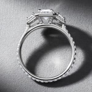 Three-stone engagement ring with emerald-cut lab diamond and pavé diamond shank by OroSpot.