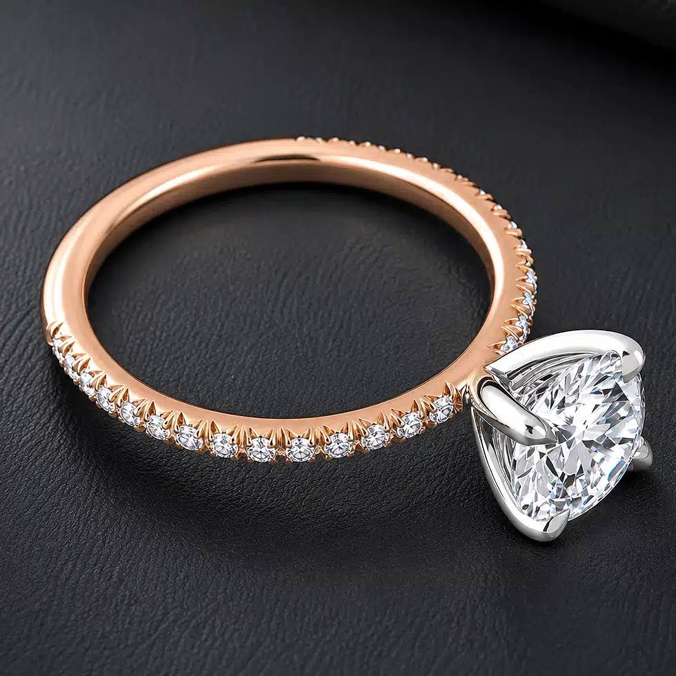 Two-tone engagement ring with a round certified lab-grown diamond, platinum prongs, rose gold band, and natural diamond accents.