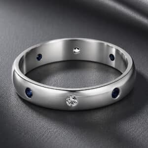 14K white gold rounded wedding band featuring burnish-set blue sapphires and diamonds in a slim 3.3mm comfort profile.