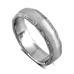 Men’s dodecagon matte finish wedding ring with angled hand-engraved sides in 14K gold.