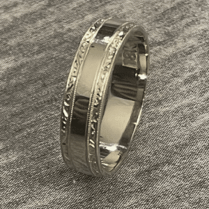 Vintage Art Deco men’s wedding ring in white unplated 18K gold with high polish finish and precise engraved side stripes.