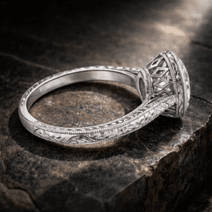 Hand engraved bezel vintage cathedral engagement ring with milgrain detailing and architectural open gallery photographed on dark textured stone background.