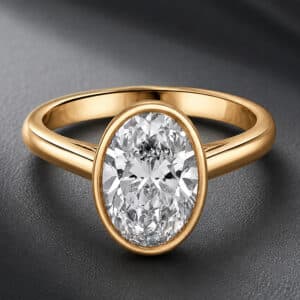 Modern bezel-set oval lab-grown diamond engagement ring in 14k yellow gold with a sleek minimalist design and high-polish finish.