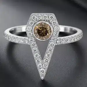 Art Deco-inspired engagement ring featuring a round brown diamond in a geometric shield-shaped diamond halo with a pavé diamond band in white gold.