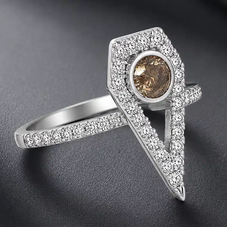 White gold engagement ring with a round brown diamond center stone, shield-shaped diamond halo, and pavé-set diamond shank.