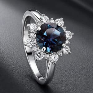 Angled view of a modern alexandrite ring with a diamond halo and polished precious metal band.