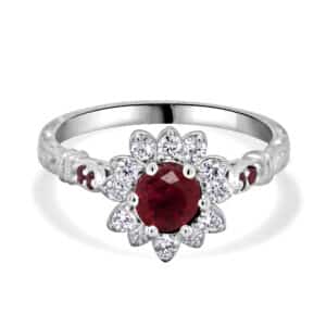 Vintage ruby diamond flower ring with round ruby, halo of G-VS diamonds, and pavé rubies on shoulders.