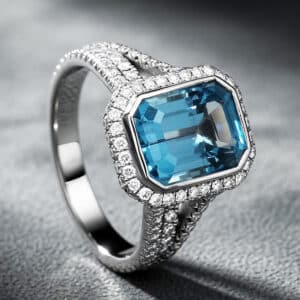 Emerald-cut blue topaz engagement ring with diamond halo and triple split shank in 14K white gold by OroSpot.
