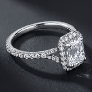 Emerald cut diamond halo engagement ring with pavé diamond band in white gold.