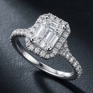 Certified emerald cut diamond engagement ring with natural diamond halo and diamond-accented shank.