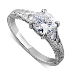 Antique cushion cut diamond ring with trillion side stones and hand engraving by OroSpot.