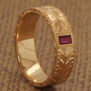 Hand-carved Art Deco men's wedding band in solid 18K yellow gold with single vibrant ruby centerpiece, vintage-inspired elegant design