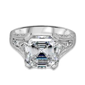 Vintage Asscher cut diamond engagement ring with hand engraving, trillion side stones, pavé accents, and Art Deco filigree details.