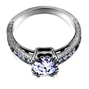 Vintage-inspired solitaire diamond engagement ring with split prongs and hand-engraved Art Deco detailing in 14K white gold.