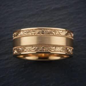 Bold gold cigar band ring for men with engraved vintage detailing and satin center.