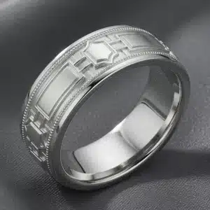 White gold Art Deco architectural wedding band featuring geometric panel details and a central keystone motif viewed from the front-left angle.